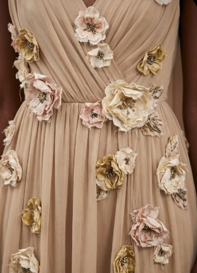 A detailed shot of the beige, Grecian-style Rodarte chiffon dress with distressed floral appliqués, worn during the ceremony.